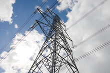 Looking Up At A Towering Metal Electricity Pylon And A Bright Sky