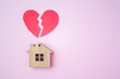 © Quils - Divorce, division of property, poverty and no money concept. Wooden house with broken heart on bright pink background. Mortgage, rent, realtor