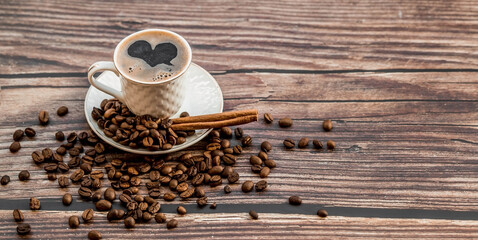 Cafes and restaurants. A mug of invigorating black coffee and coffee beans on a wooden background. Place for the label. The concept of hot drinks.