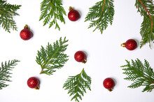 Thuja Twigs And Christmas Red Balls On A White Background