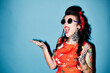 © Westend61 - Portrait of tattooed woman against blue background