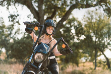 Beautiful Woman Wearing Crash Helmet While Sitting On Motorcycle Against Tree