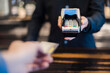 © Daniel Ingold/Westend61 - Man using credit card reader, close-up
