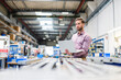 © Daniel Ingold/Westend61 - Young businessman using laptop in production hall