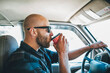 © Julius Gnoth/Westend61 - Young man with sunglasses and beard on a road trip with takeaway drink