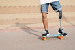 © joan corominas/Westend61 - Young man with physical disability standing on skateboard at sports court