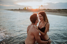 Couple Wearing Swimwear Doing Romance In Water At Beach