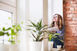 © HalfPoint/Westend61 - Woman sitting at home on the window sill, reading a book