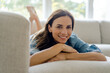 © Kniel Synnatzschke/Westend61 - Portrait of smiling mature woman lying on couch at home