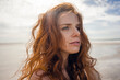 © Kniel Synnatzschke/Westend61 - Portrait of a redheaded woman on the beach