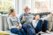 © Robijn Page/Westend61 - Grandfather talking to two girls on sofa in living room