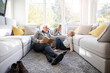 © Robijn Page/Westend61 - Two girls and grandfather reading book in living room