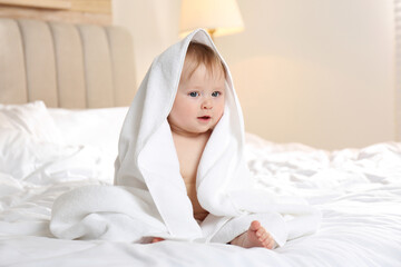 Canvas Print - Cute little baby with soft towel on bed after bath