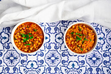 Two Bowls Of Vegan Stew With Chick-peas, Red Lentils, Tomatoes, Spanish Onions And Mint