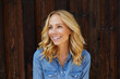 © philipp nemenz/Westend61 - Happy blond woman in front of wooden wall
