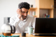 © Sigrid Gombert/Westend61 - Portrait of businessman at desk looking at laptop