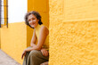 © Tania Cervi√°n/Westend61 - Happy mature woman sitting on doorway against wall