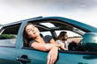 © UWE_UMSTAETTER/Westend61 - Smiling young woman leaning out of car window