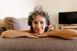 © Tania Cervi√°n/Westend61 - Mature woman resting on sofa at home