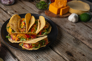 Wall Mural - Plate with fragrant mexican tacos on rustic wooden table with ingredients for cooking background. Concept of traditional meal. View from above. Recipe book with appetizing food. Space for text.