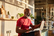 © Jo Kirchherr/Westend61 - Smiling businessman concentrating on work while using laptop at home