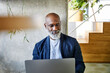© Jo Kirchherr/Westend61 - Smiling man working on laptop at home