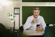 © Joseffson/Westend61 - Businessman using mobile phone while drinking coffee at cafeteria
