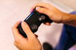 © JOSEP M ROVIROSA/Westend61 - Hands of young man holding controller while playing video game at home