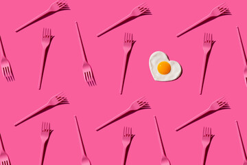 Pattern of pink plastic forks with single heart shaped fried egg