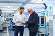 © Robijn Page/Westend61 - Senior manager pointing at machine part while discussing with engineer by machinery in factory