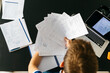 © JOSEP M ROVIROSA/Westend61 - Man holding papers with mathematical equations while sitting at table