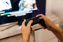 Hands Of Male Gamer Holding Controller While Playing At Home