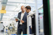 © Robijn Page/Westend61 - Businessmen discussing over digital tablet while standing at factory