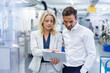 © Robijn Page/Westend61 - Confident blond businesswoman discussing over digital tablet with male colleague at factory