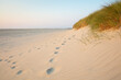 © Wilfried Wirth/Westend61 - Footprints by marram grass on sand dune at beach against sky during sunset