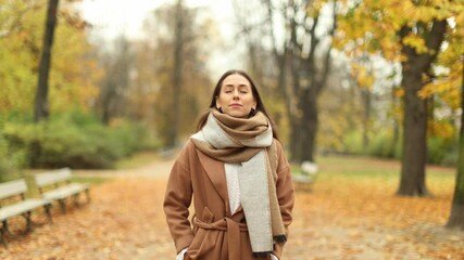 Wall Mural - beautiful young woman standing in the park and enjoying with her eyes closed