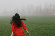 © Duet Postscriptum/Stocksy - Girl in red dress escapes into the fog