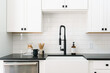 © Ali Harper Photography/Stocksy - Black and white farmhouse kitchen sink