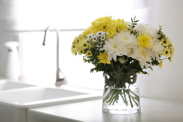 Wall Mural - Vase with beautiful chrysanthemum flowers on countertop in kitchen, space for text. Interior design