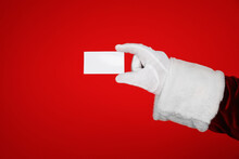 Santa Claus Holding Blank Card On Red Background, Closeup Of Hand. Space For Text