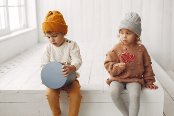 Sticker - Children in a studio. Little girl with her brother. Boy in a white sweater.