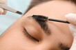 Young man undergoing eyebrow correction procedure in beauty salon, closeup