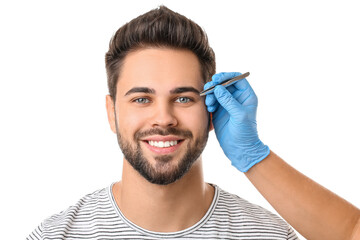 Sticker - Young man undergoing eyebrow correction procedure on white background