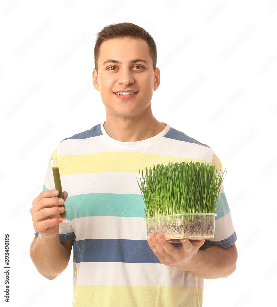 Young man with wheatgrass and juice on white background