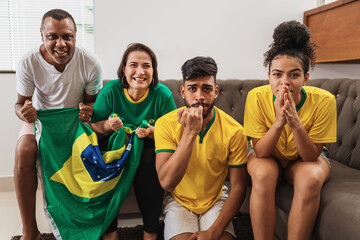 Wall Mural - real latin american family watching football on television, apprehensive about the penalty