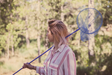 a girl in a striped shirt holds a butterfly net