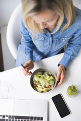 Wall Mural - Over view - Woman eating healthy salad in office