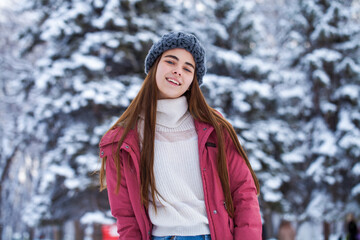 Close up portrait of a young beautiful brunette woman in winter park