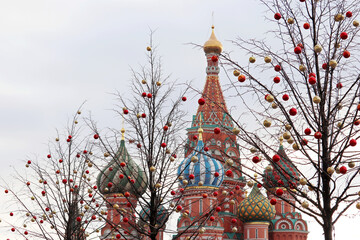 Wall Mural - Christmas decorations on background of St. Basil's Cathedral on Red square, selective focus. New Year in Russia, festive balls on a tree branches