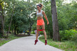 Young strong fitness woman in sportswear train with stretchable rubber in park